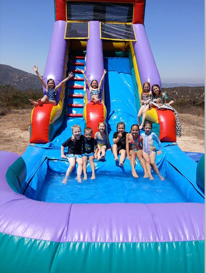 Kids enjoying the water slide at a Solid Rock Homestead event